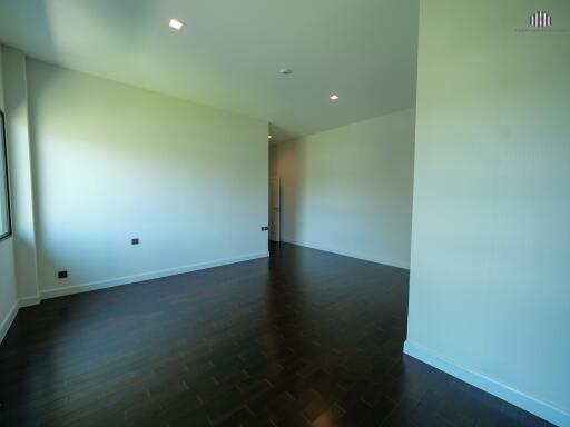 spacious living room with dark hardwood floors and white walls