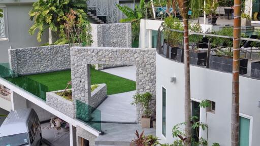 Modern multi-level building with greenery and stone architecture