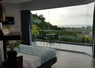 Bedroom with large glass windows overlooking a scenic view