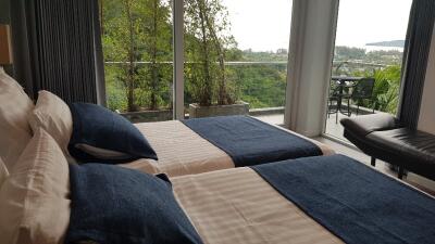 Modern bedroom with twin beds and balcony with scenic view