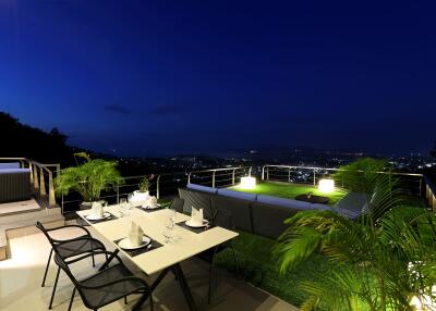 Outdoor dining area with distant city view at night