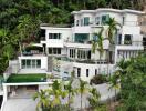 Exterior view of a luxury multi-level house with a garden and pool