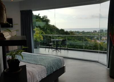 Bedroom with large glass windows offering a scenic view