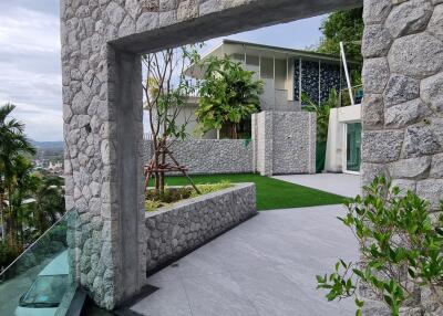 Modern stone patio with lush greenery and contemporary architecture