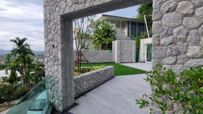 Modern stone patio with lush greenery and contemporary architecture