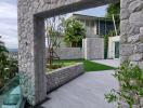 Modern stone patio with lush greenery and contemporary architecture