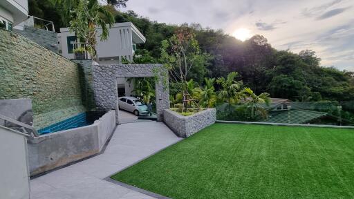 Exterior view with lawn, stone wall, and carport