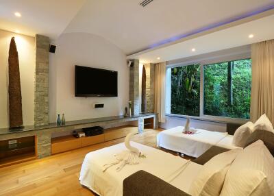 Modern bedroom with twin beds, large window, and television