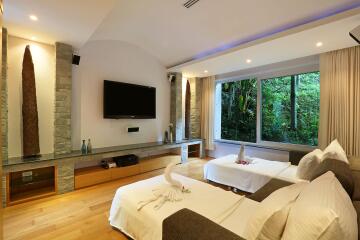 Modern bedroom with twin beds, large window, and television