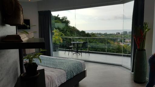 Bedroom with a large glass window offering a scenic view