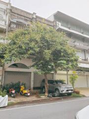 Front view of a residential building with parked vehicles