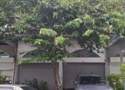 Front view of a building with cars parked in the driveway