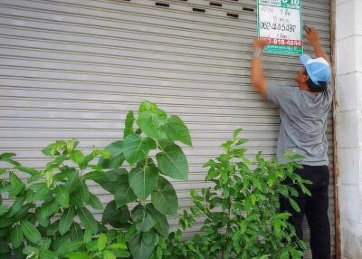 A person putting up a sign on a closed garage door