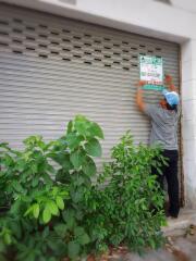 A person putting up a sign on a closed garage door