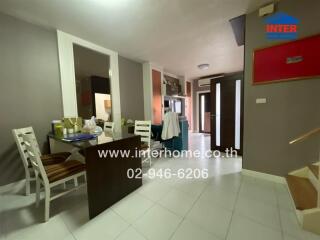 Dining area with table, chairs, and view to the entrance