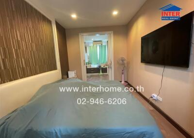 Modern bedroom with wall-mounted TV and ensuite bathroom