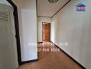 Hallway with tiled floor and wooden door at the end