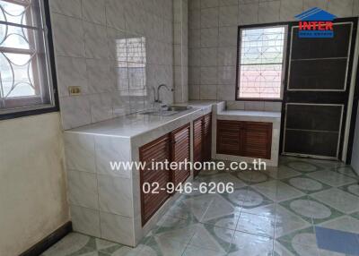 Modern kitchen with tiled walls and countertops, wooden cabinet doors, and large windows