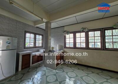 Spacious kitchen with multiple windows and a tiled floor