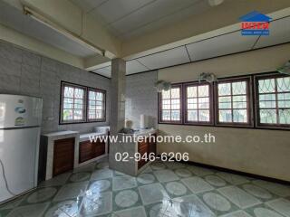 Spacious kitchen with multiple windows and a tiled floor