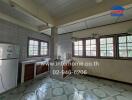 Spacious kitchen with multiple windows and a tiled floor