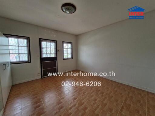 Empty bedroom with tiled floor and windows