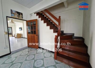 Staircase and entrance area with view into another room