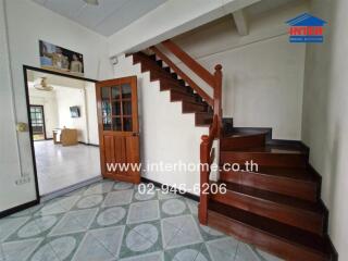 Staircase and entrance area with view into another room