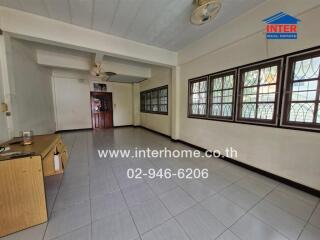 Spacious living room with multiple windows and tile flooring