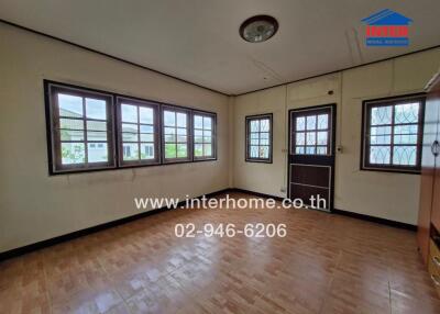 Living room with multiple windows and wooden flooring