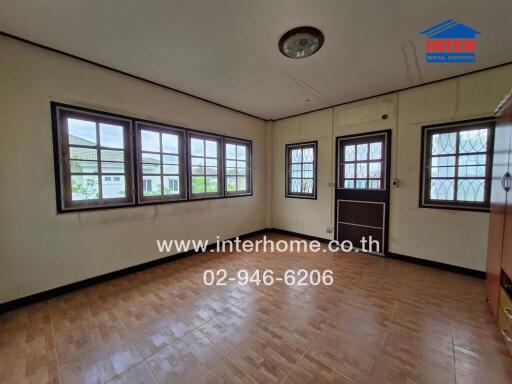 Living room with multiple windows and wooden flooring