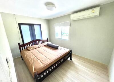 Spacious bedroom with natural light, a bed, and air conditioning