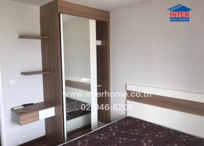 Modern bedroom with a large wardrobe, shelves, and a mirror