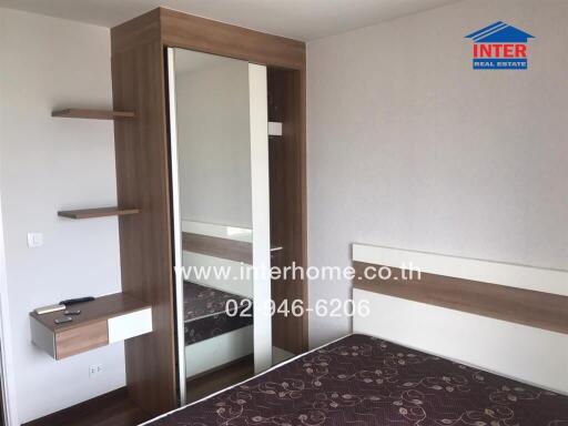 Modern bedroom with a large wardrobe, shelves, and a mirror