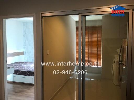 View of a modern apartment with a bedroom, sliding glass doors, and laundry area.