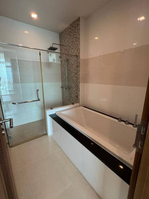 A modern bathroom with a bathtub and a glass-enclosed shower