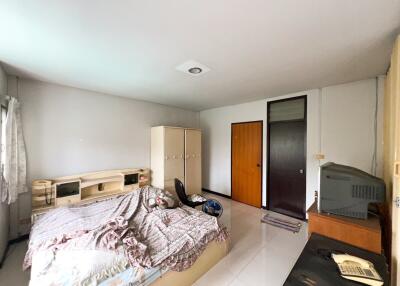 Spacious bedroom with bed, wardrobe, and television