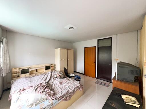 Spacious bedroom with bed, wardrobe, and television