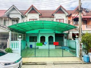 Front view of a townhouse with a green covered carport