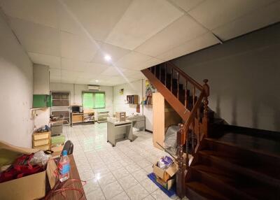 Main living space with staircase, desks, and wooden furniture