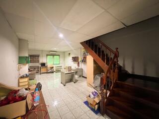 Main living space with staircase, desks, and wooden furniture