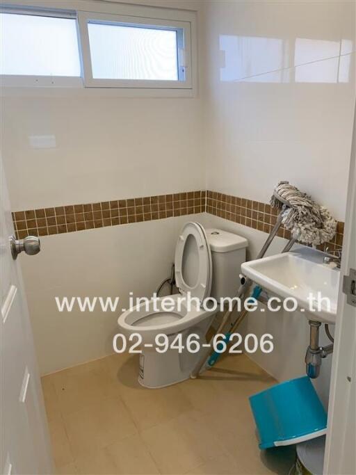 Small bathroom with a toilet, sink, and window