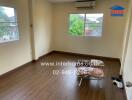 Empty bedroom with wooden floor, air conditioner, and windows