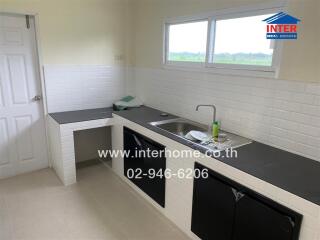 Modern kitchen with a sink, counter space, and overhead window