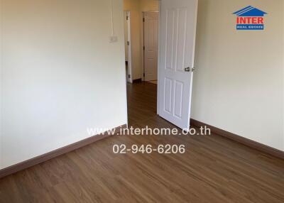 Empty room with wooden flooring and open door