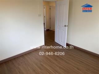 Empty room with wooden flooring and open door