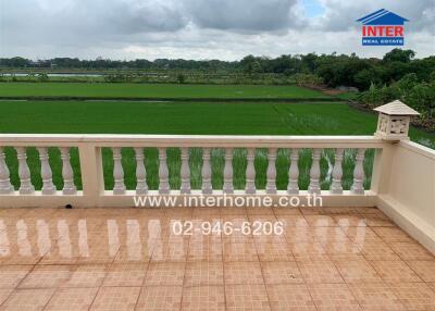 Spacious balcony with scenic view of green fields