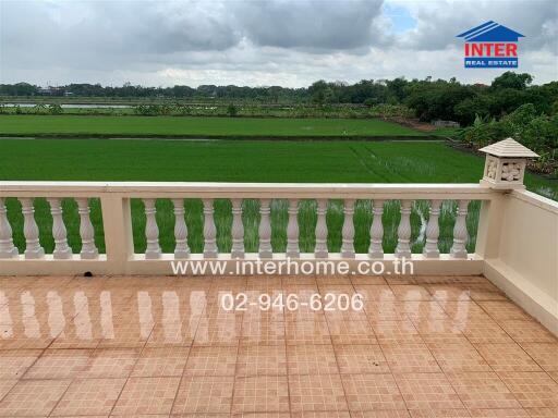 Spacious balcony with scenic view of green fields