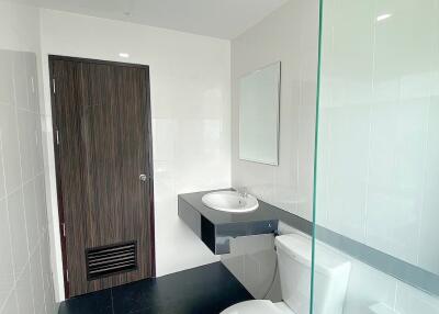 Modern bathroom with glass partition and dark floor tiles