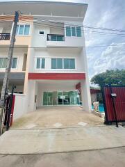 Front view of a modern townhouse with glass doors and a small gate